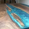 Teal epoxy wave detail on black walnut round dining table
