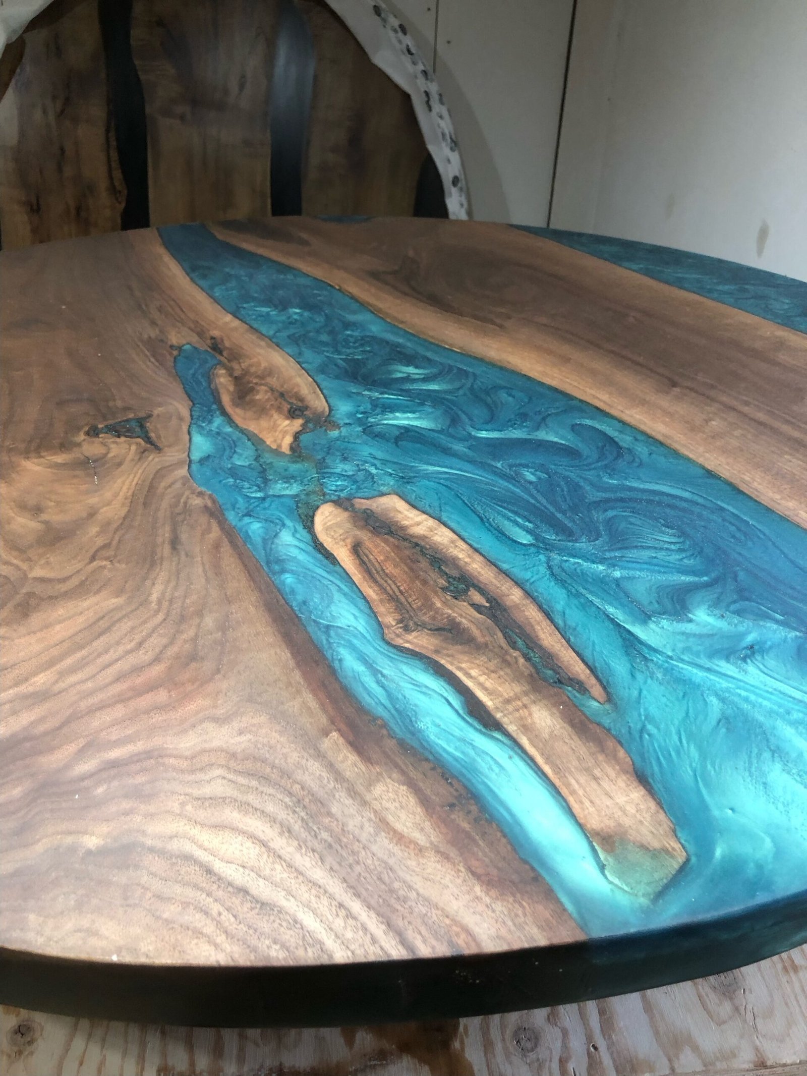 teal-epoxy-wave-detail-black-walnut-round-dining-table Teal epoxy wave detail on black walnut round dining table