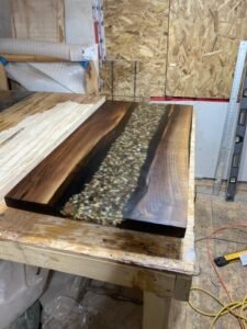 Custom black walnut office desk with clear epoxy river and natural rock features